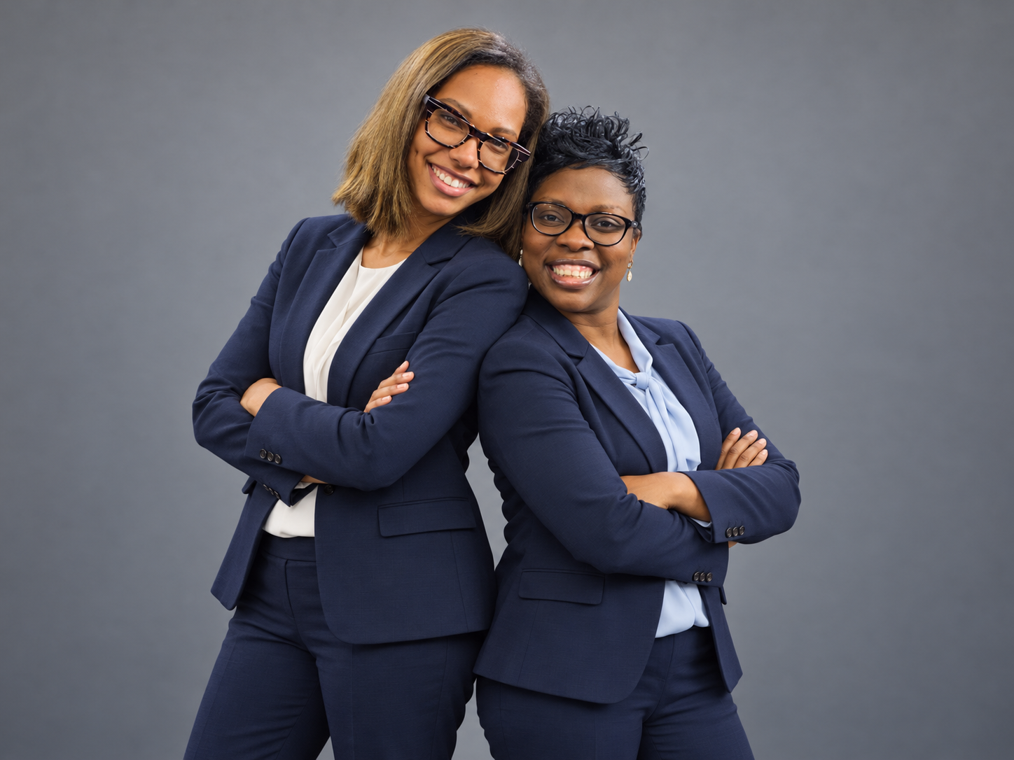 Eboni Speight and Nichelle Stephens, co-founders of YOU Life Plan, standing back to back in navy suits